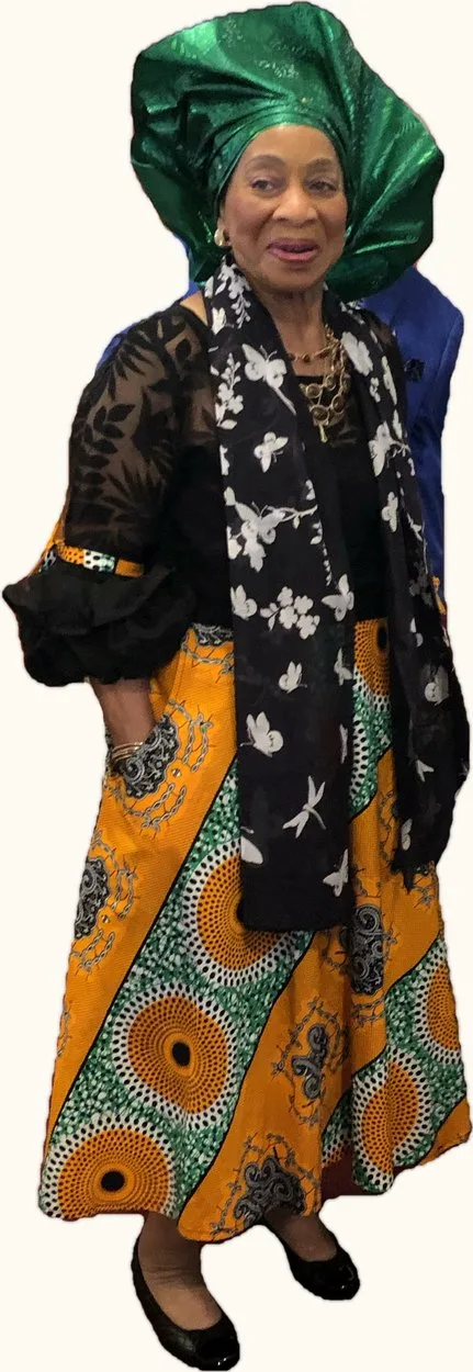 Missionary Katherine Cash Griffey wearing a green gele and an orange and black print ensemble.